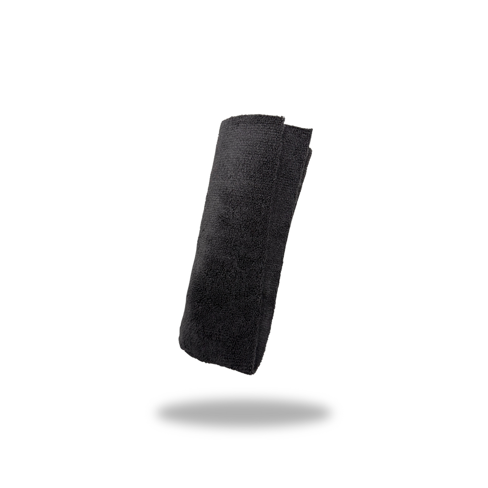 Folded black microfiber towel isolated on white background for VINYL + RUBBER care and cleaning.