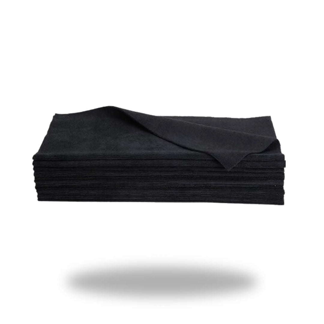 Stack of folded black cloths with one corner lifted, showcasing the fabric texture of Black Edgeless 16