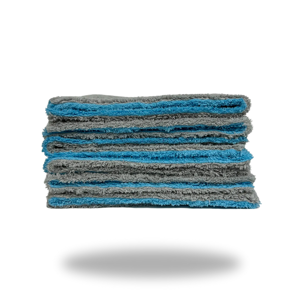 Stack of folded gray and blue Edgeless Dual-Faced Microfiber cloths showing soft texture and clean edges