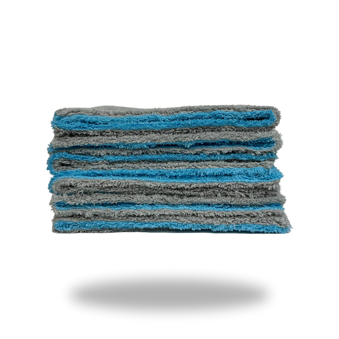 Stack of folded gray and blue Edgeless Dual-Faced Microfiber cloths showing soft texture and clean edges