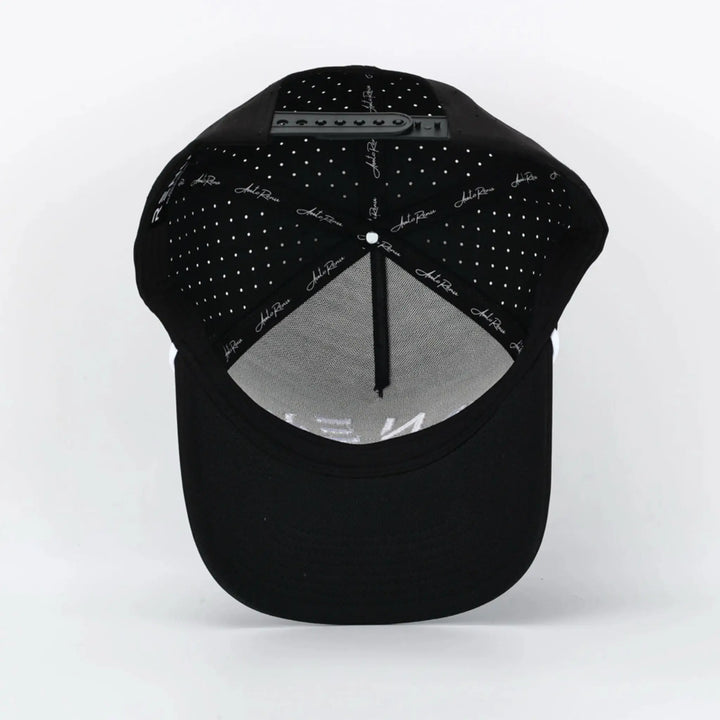 Inside view of the Invert Black cap showing perforated panels and adjustable strap detail.