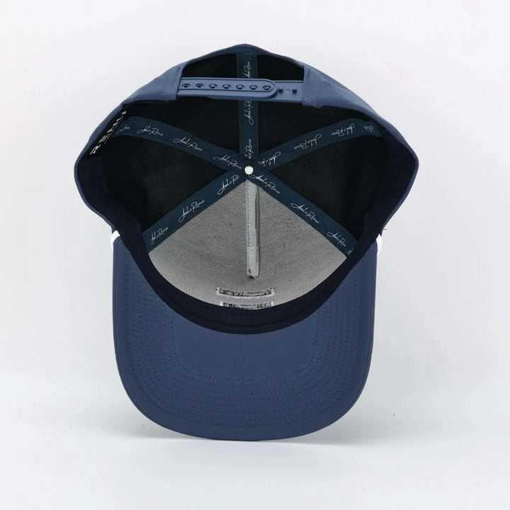 Interior view of a navy blue cap with adjustable strap, featuring Signature Blue branding on inner seams.