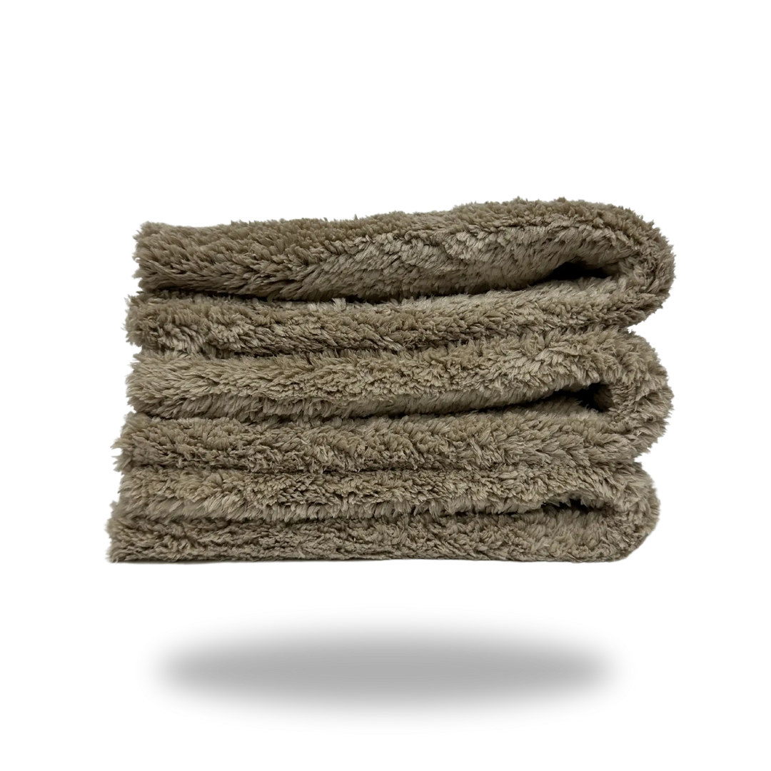 Soft folded tan towel made of Tan 600 Edgeless Microfiber with a plush texture and no visible edges.